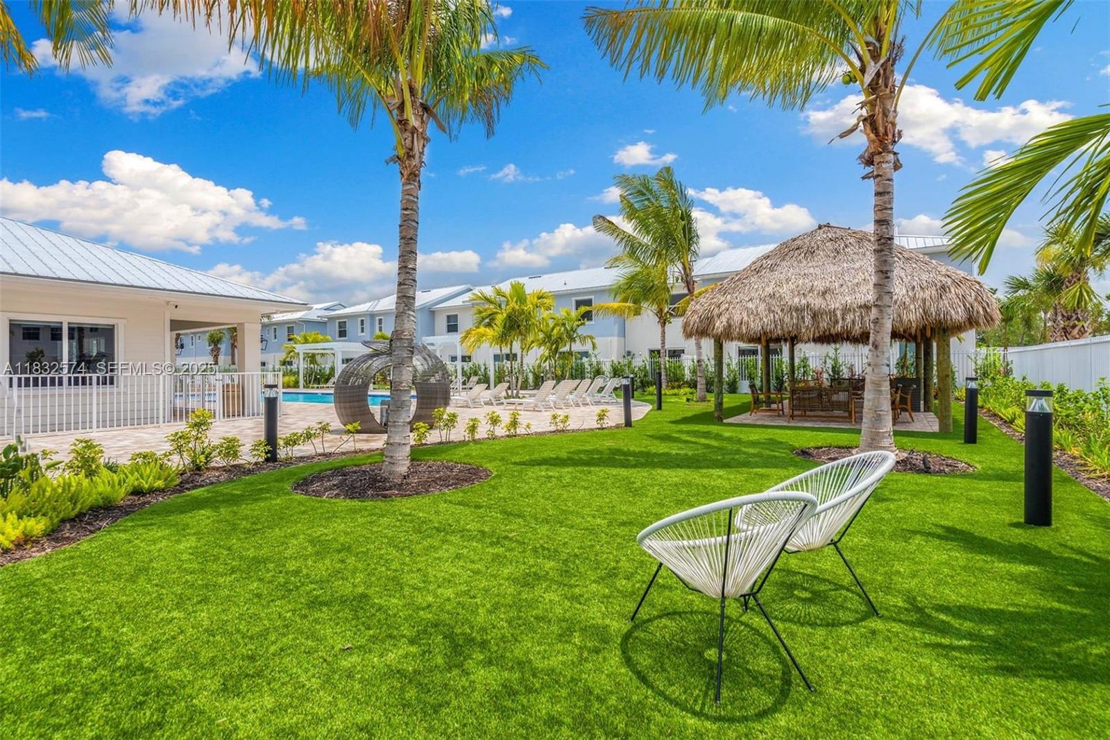 3645 Blue Fin Way, Unit 101 Fort Myers, FL 33916 - Photo 5 of 8 a view of a chair and tables in the patio with a garden