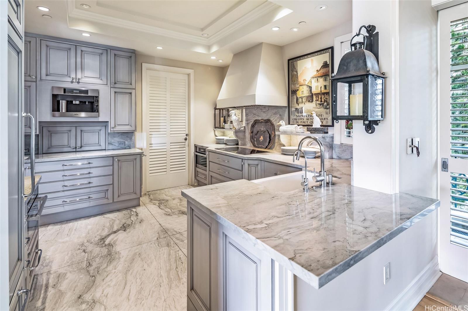 a kitchen with kitchen island granite countertop a large counter top stainless steel appliances and cabinets