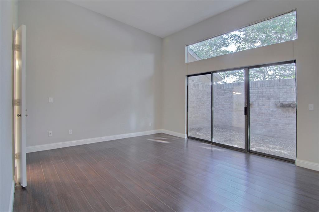 14822 Sopras Circle Addison, TX 75001 - Photo 15 of 33 a view of an empty room with wooden floor and a large window