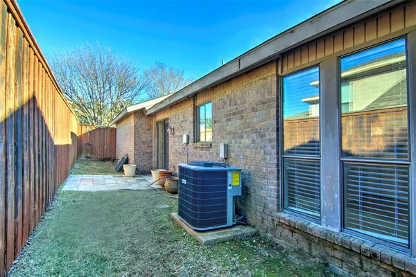 a view of a pathway of a house with backyard and wooden fence