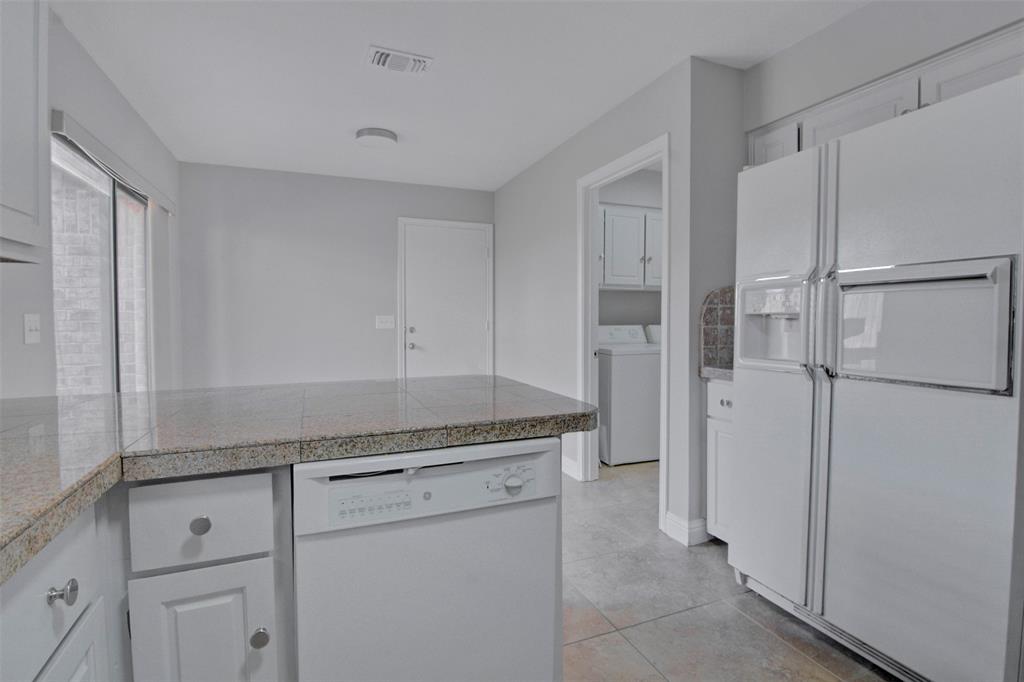 14822 Sopras Circle Addison, TX 75001 - Photo 4 of 33 a kitchen with a refrigerator and cabinets