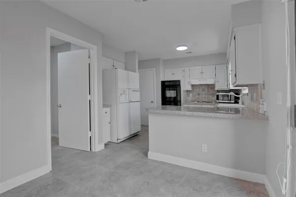 a kitchen with stainless steel appliances granite countertop a refrigerator a stove and a sink