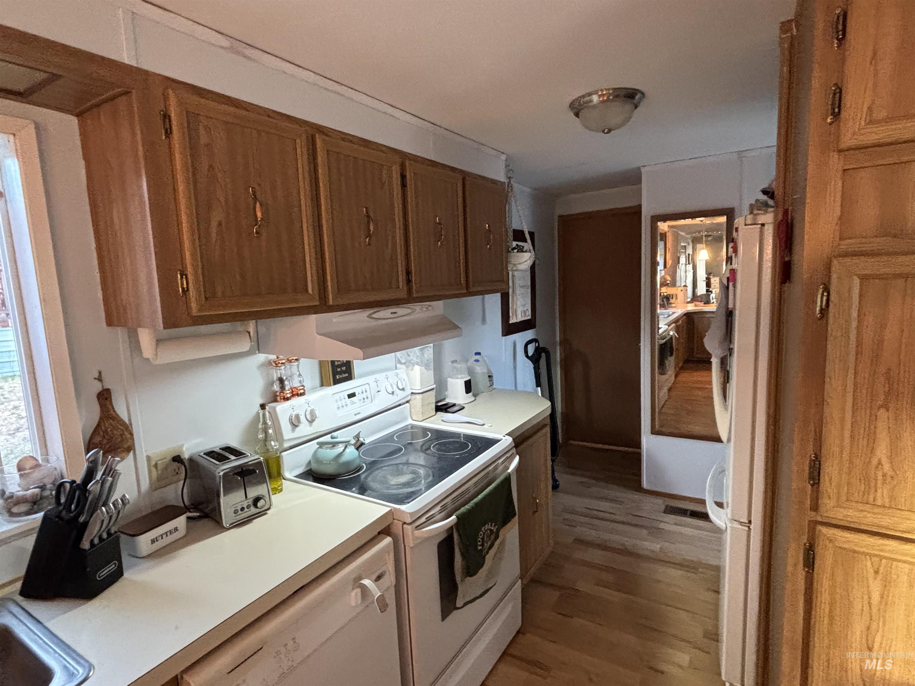 609 North Almon Street, Unit 3024 Moscow, ID 83843 - Photo 6 of 17 Kitchen with white appliances, wood finished floors, light countertops, and under cabinet range hood