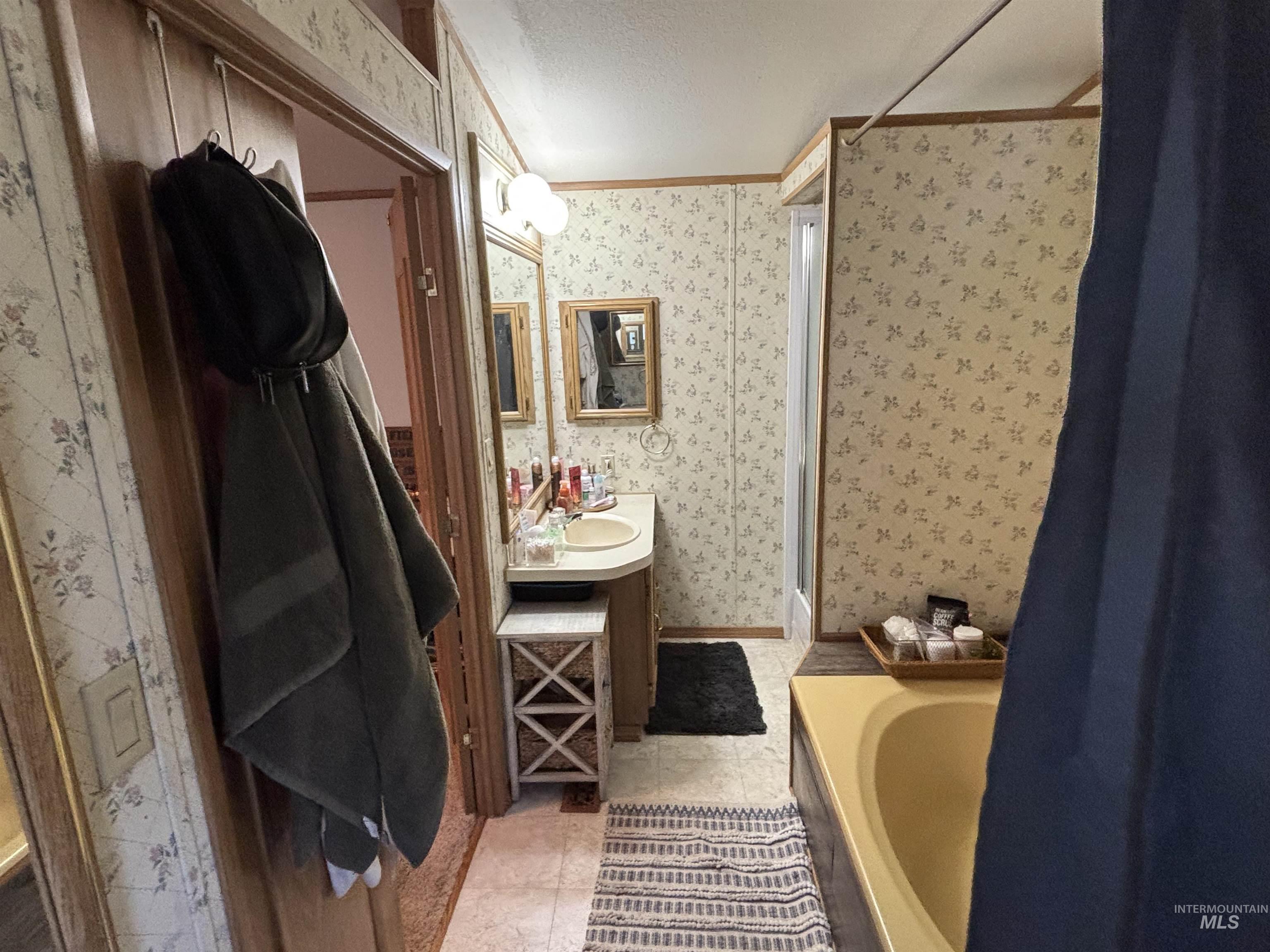 609 North Almon Street, Unit 3024 Moscow, ID 83843 - Photo 10 of 17 Bathroom featuring wallpapered walls, ornamental molding, vanity, a bathtub, and a textured ceiling
