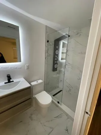 a bathroom with a toilet sink and shower