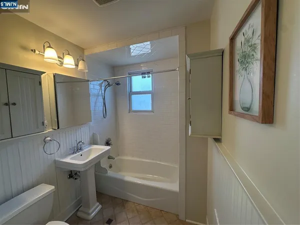 a bathroom with a sink mirror toilet and bathtub