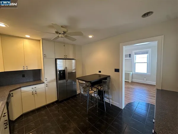 a kitchen that has a table chairs and a refrigerator