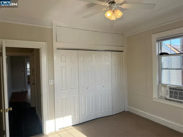 a view of empty room with window and chandelier fan