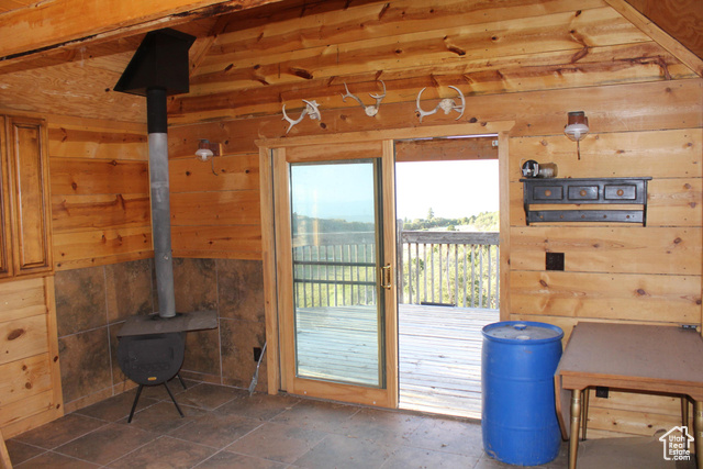 Undisclosed Address Summit, UT 84772 - Photo 18 of 24 Doorway to outside featuring wooden walls, a wood stove, and stone tile floors