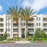 a front view of a multi story residential apartment building with a yard and entryway