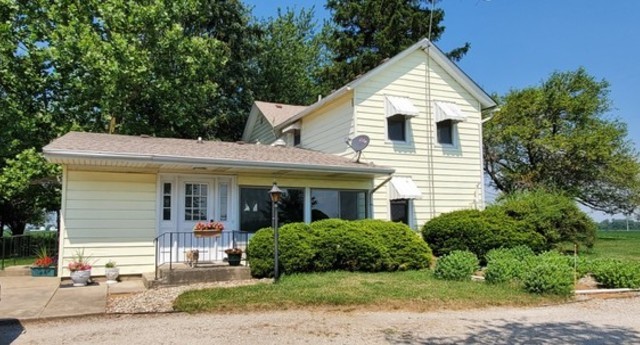 15525 West Hoff Road Manhattan, IL 60442 - Photo 5 of 30 a view of a white house next to a yard with potted plants
