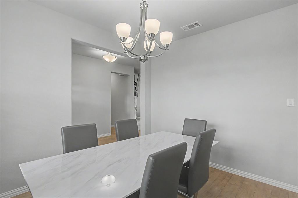 185 Chester Road Springtown, TX 76082 - Photo 12 of 40 Dining area featuring wood-finish flooring, a contemporary chandelier, and recessed lighting in the hallway