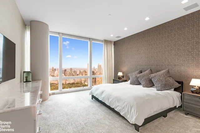 a bedroom with a large bed and a flat tv screen on dresser