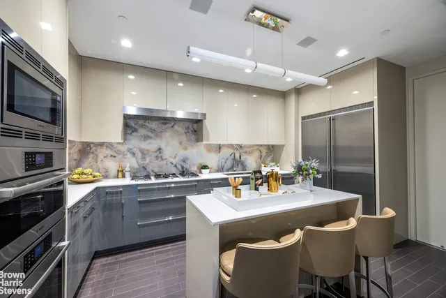a kitchen with a sink a stove and chairs
