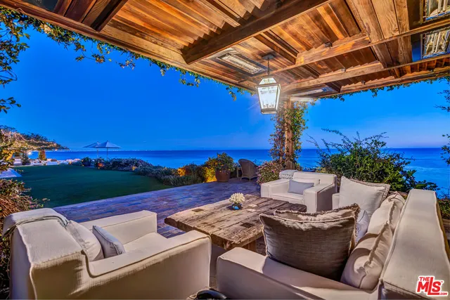 a living room with furniture chandelier and a large window