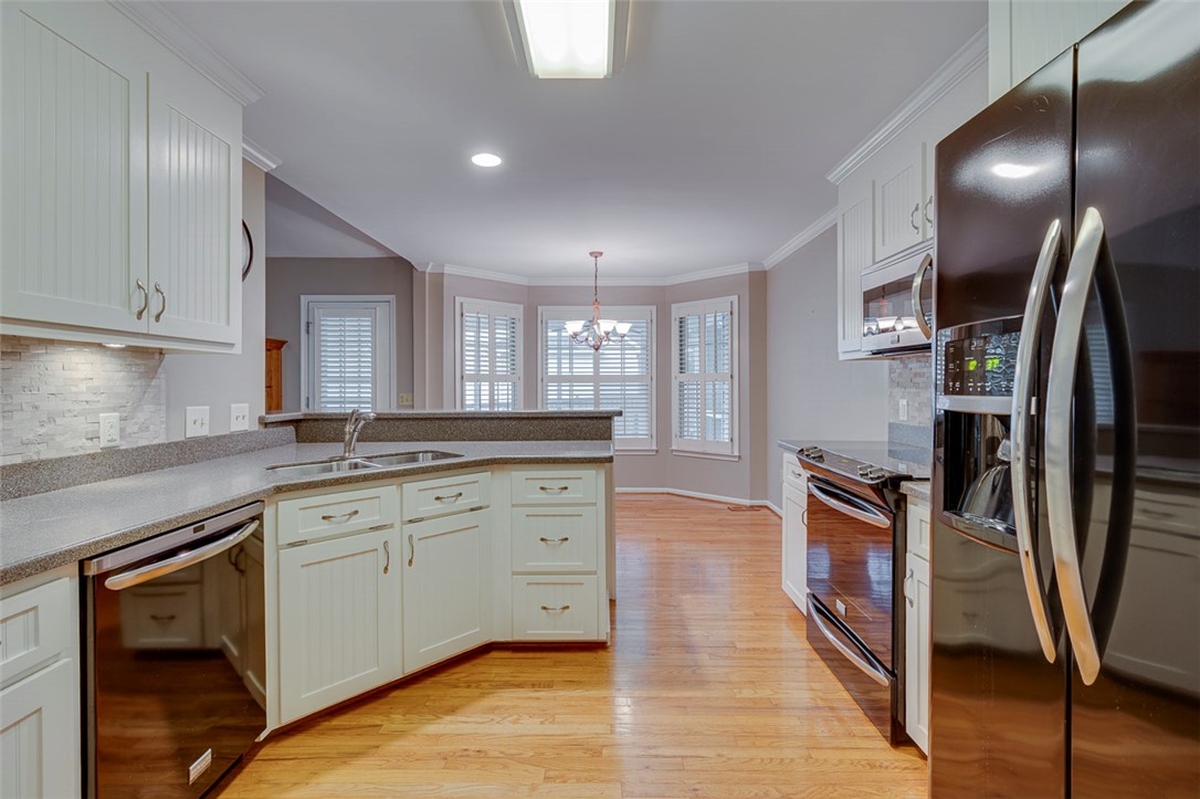 302 Wild Rice Drive Simpsonville, SC 29681 - Photo 17 of 44 Warm hardwood floors anchor this functional kitchen layout complete with white cabinetry and stone countertops.