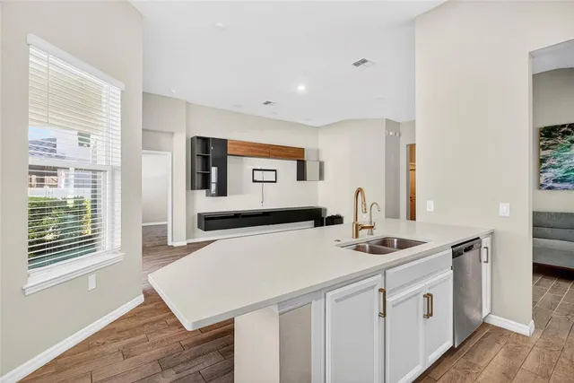 a kitchen with stainless steel appliances white cabinets and wooden floor