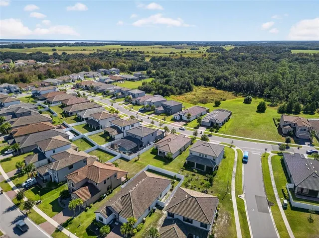 an aerial view of residential houses with outdoor space and swimming pool