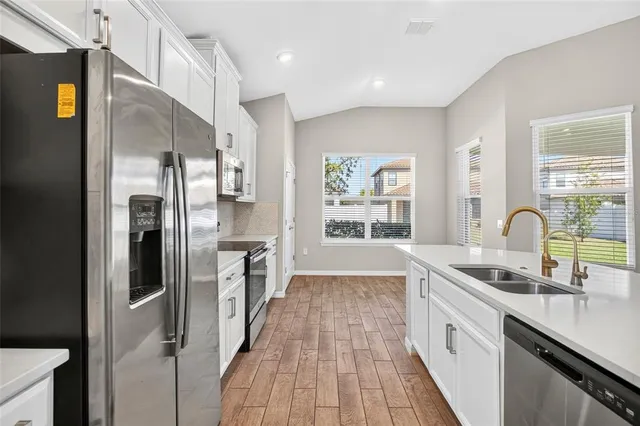 a kitchen with refrigerator a sink and cabinets
