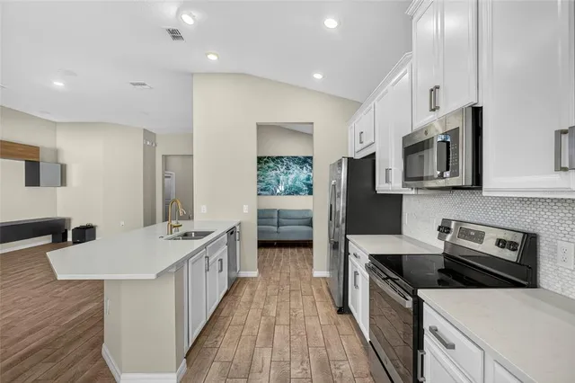 a kitchen with stainless steel appliances a stove microwave and sink