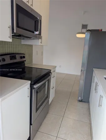 a view of empty room with a kitchen