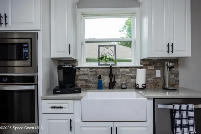 a kitchen with stainless steel appliances kitchen island granite countertop a refrigerator a sink dishwasher a stove and a dining table with wooden floor