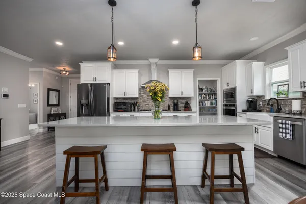 a dining room with furniture a chandelier and wooden floor
