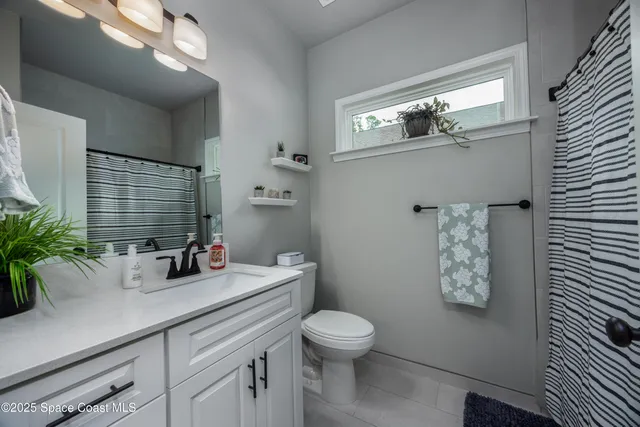 a view of a workspace with bookshelf and a window