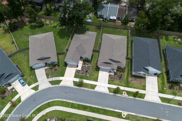 an aerial view of a house with garden space and street view