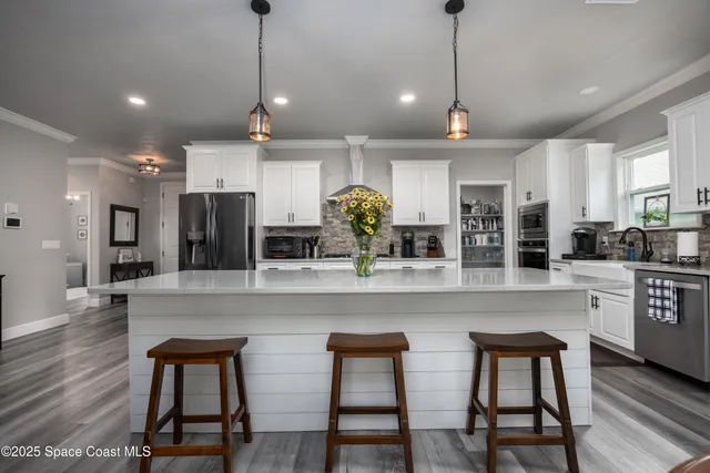 a kitchen with stainless steel appliances a dining table chairs stove and cabinets