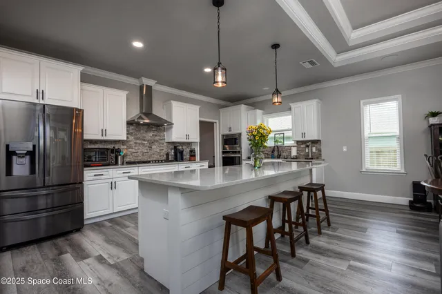 a kitchen with stainless steel appliances kitchen island granite countertop a stove a sink and a refrigerator