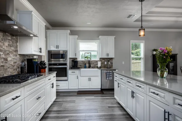 a kitchen with white cabinets and appliances