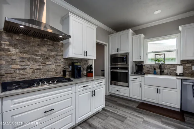 a kitchen with appliances a sink and cabinets
