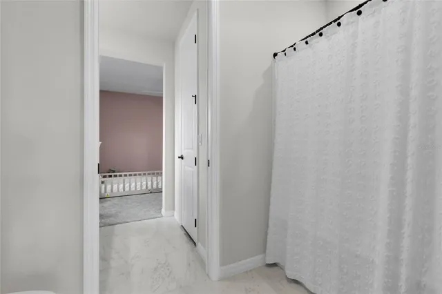 a bathroom with a sink a toilet a mirror and shower curtain