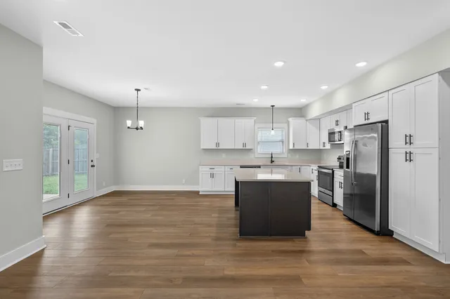 a kitchen with stainless steel appliances a refrigerator and a stove top oven