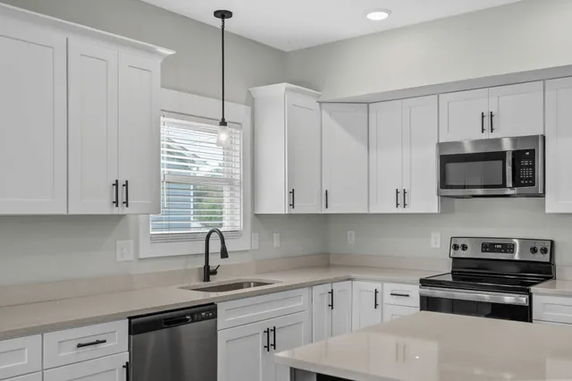 a kitchen with appliances a sink and cabinets