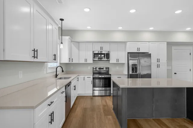 a large kitchen with stainless steel appliances double sink and cabinets