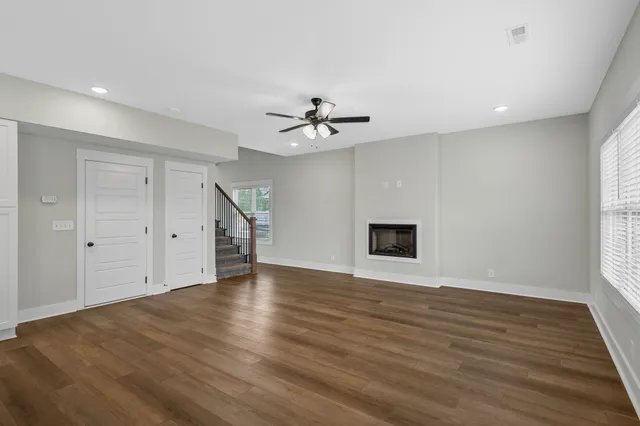 an empty room with wooden floor and ceiling fan