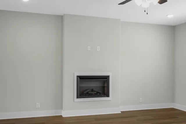a view of a small space with wooden floor and a ceiling fan