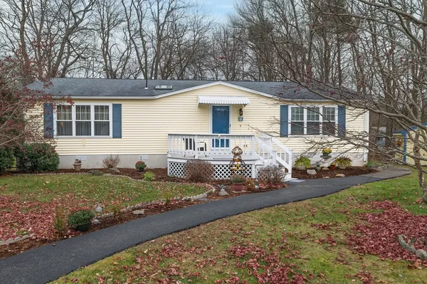 a front view of a house with a yard and lake view