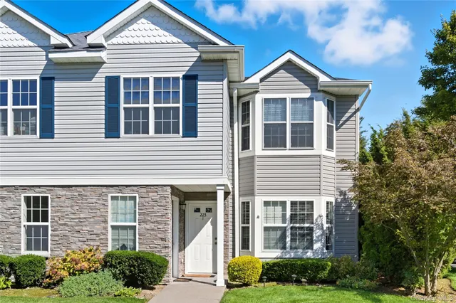 a front view of a house with a yard and potted plants