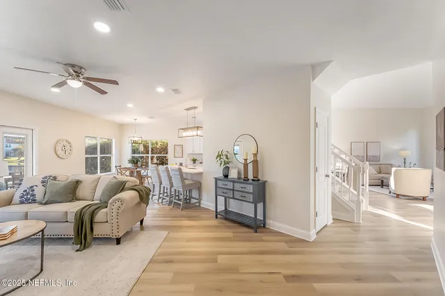 a dining room with furniture a chandelier and wooden floor