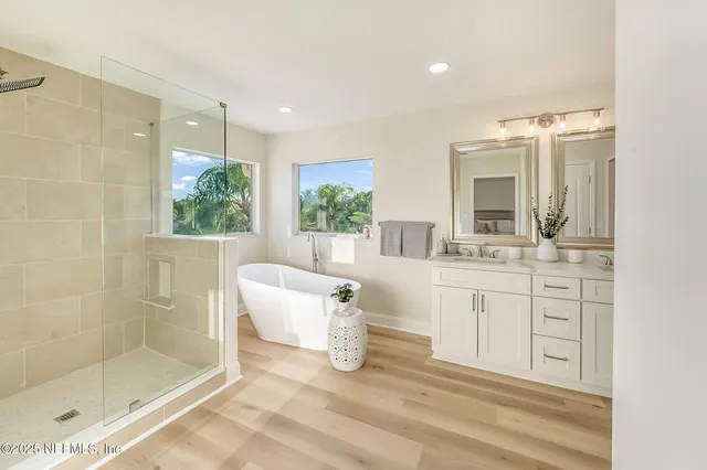 a front view of a house with a garden and tree