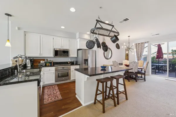 a kitchen with granite countertop a sink cabinets and stainless steel appliances