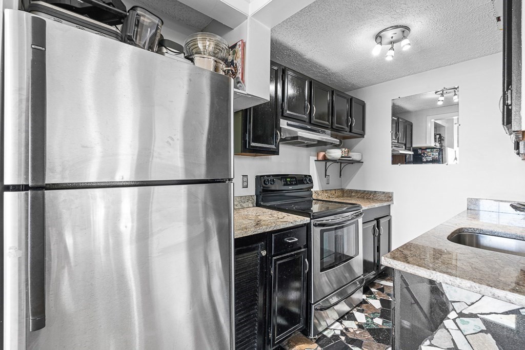 480 Commercial Street, Unit 5B Boston, MA 02109 - Photo 7 of 21 a kitchen with stainless steel appliances granite countertop a sink stove and refrigerator