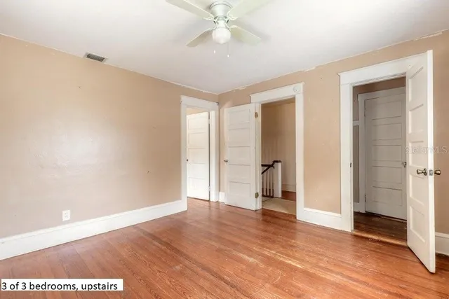 a view of an empty room with wooden floor