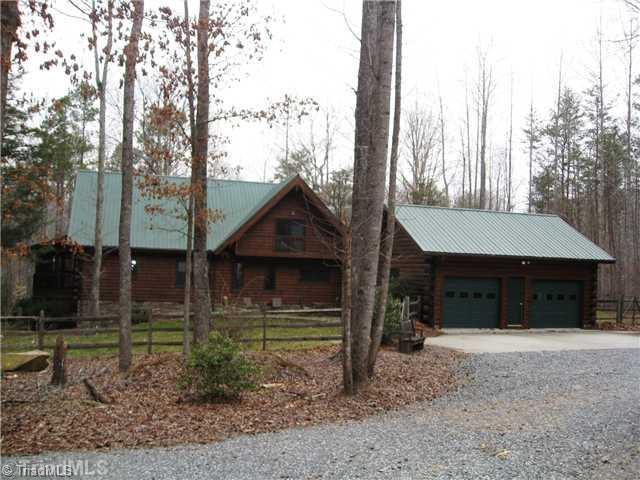 6715 Ventwood Road Climax, NC 27233 - Photo 13 of 16 Exterior Back. View of the back of the home showing the detached garage, patio area, fenced backyard.