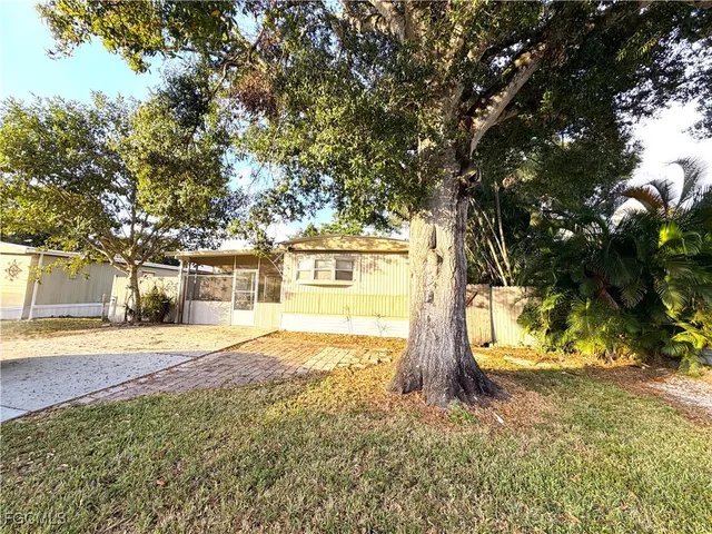 a view of a house with backyard and trees