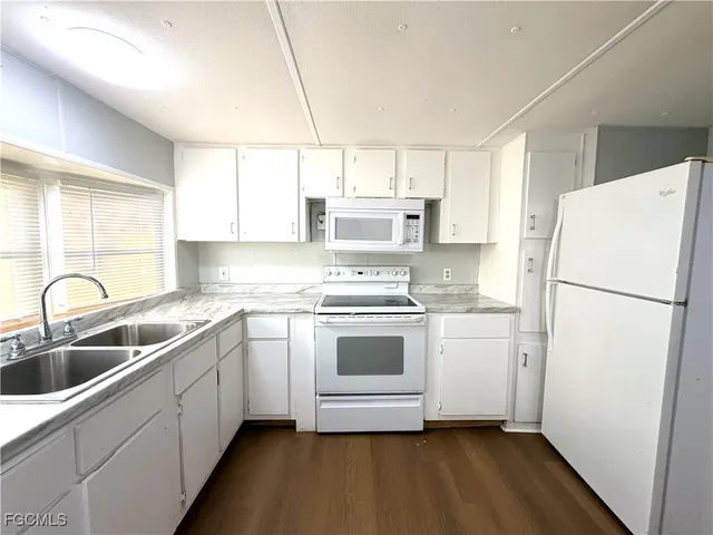 a kitchen with a refrigerator sink and white cabinets