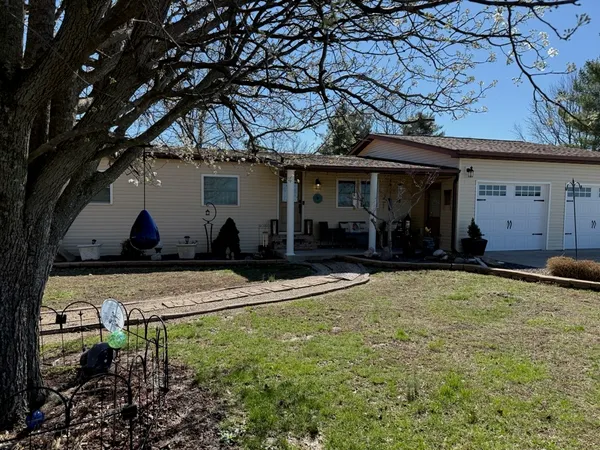 a view of a house with backyard and a tree